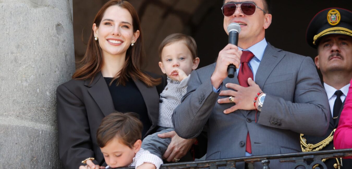 Presidente del Ecuador junto a su familia y un guardia presidencial en un balcón del palacio presidencial.