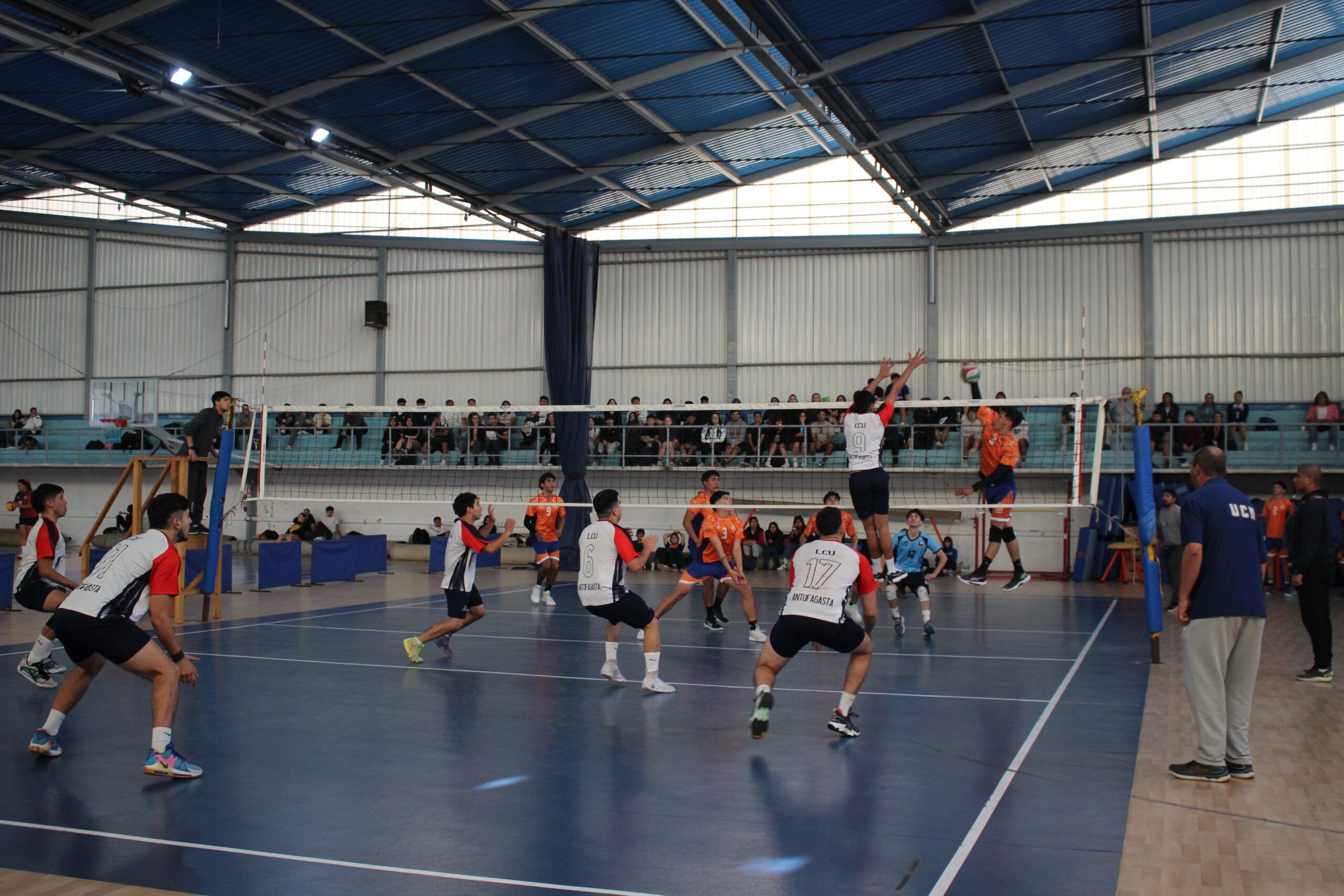 Jugador de voleibol realizando un remache en partido.
