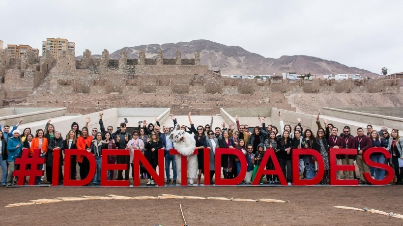 Festival Identidades 2024: Asistentes en una foto tomada frente al museo de las Ruinas de Huanchaca con el fondo de este.